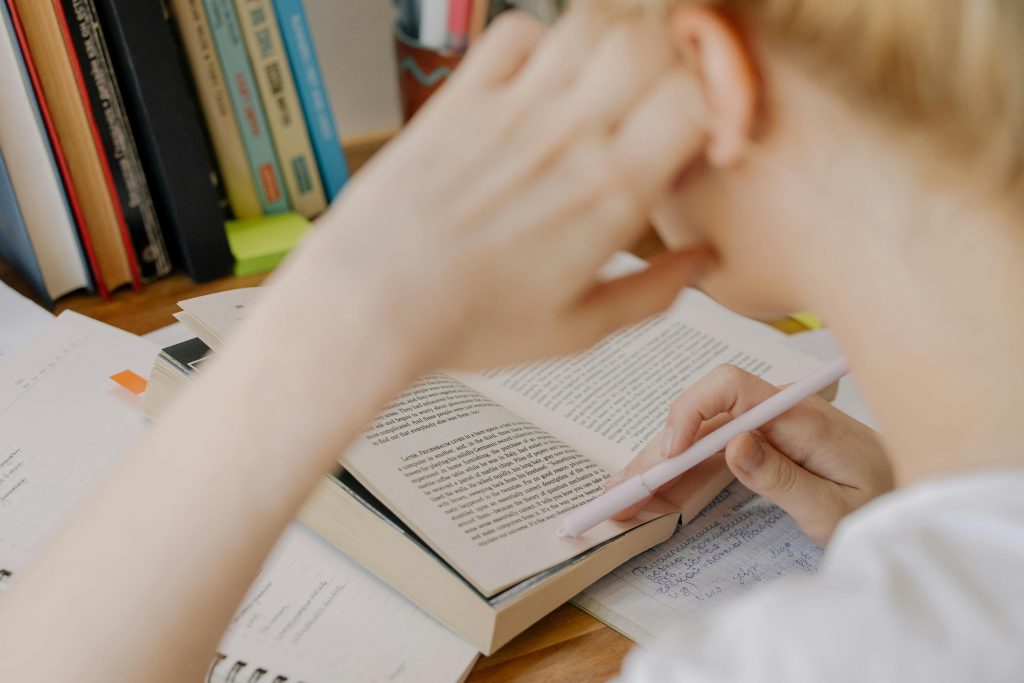 A student studying diligently with an open textbook, emphasizing concentration and learning.